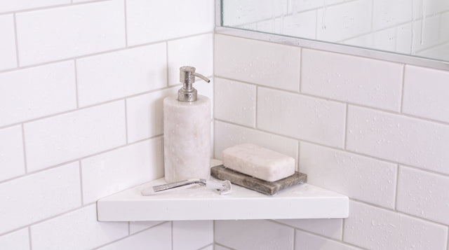 White shower shelf holding soap in a bathroom