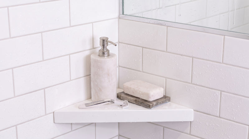 White shower shelf holding soap in a bathroom